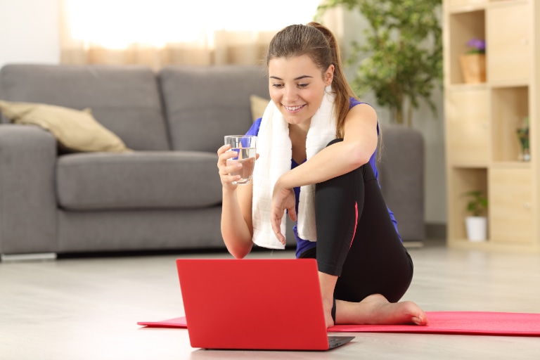 woman drinking glass of water during excercise