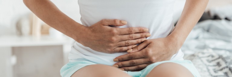 woman holding stomach in pain