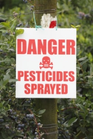 "danger pesticides sprayed" sign in field