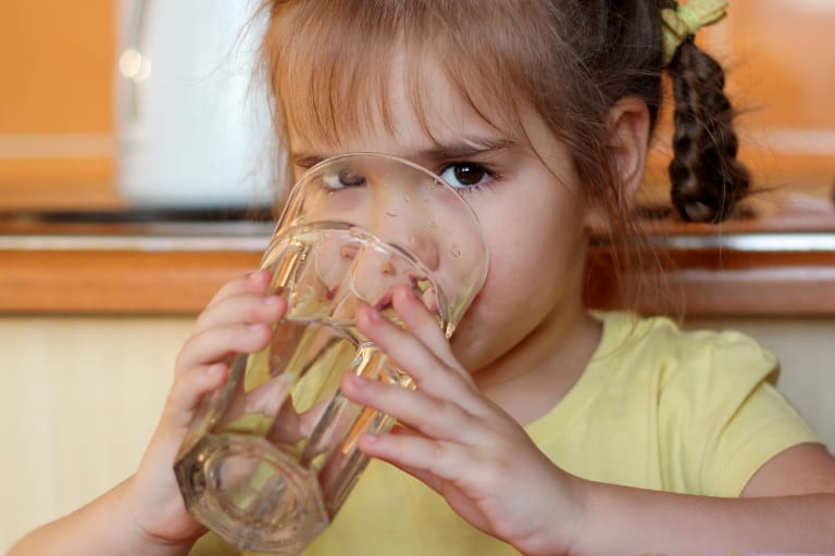 young girl drinking glass of water